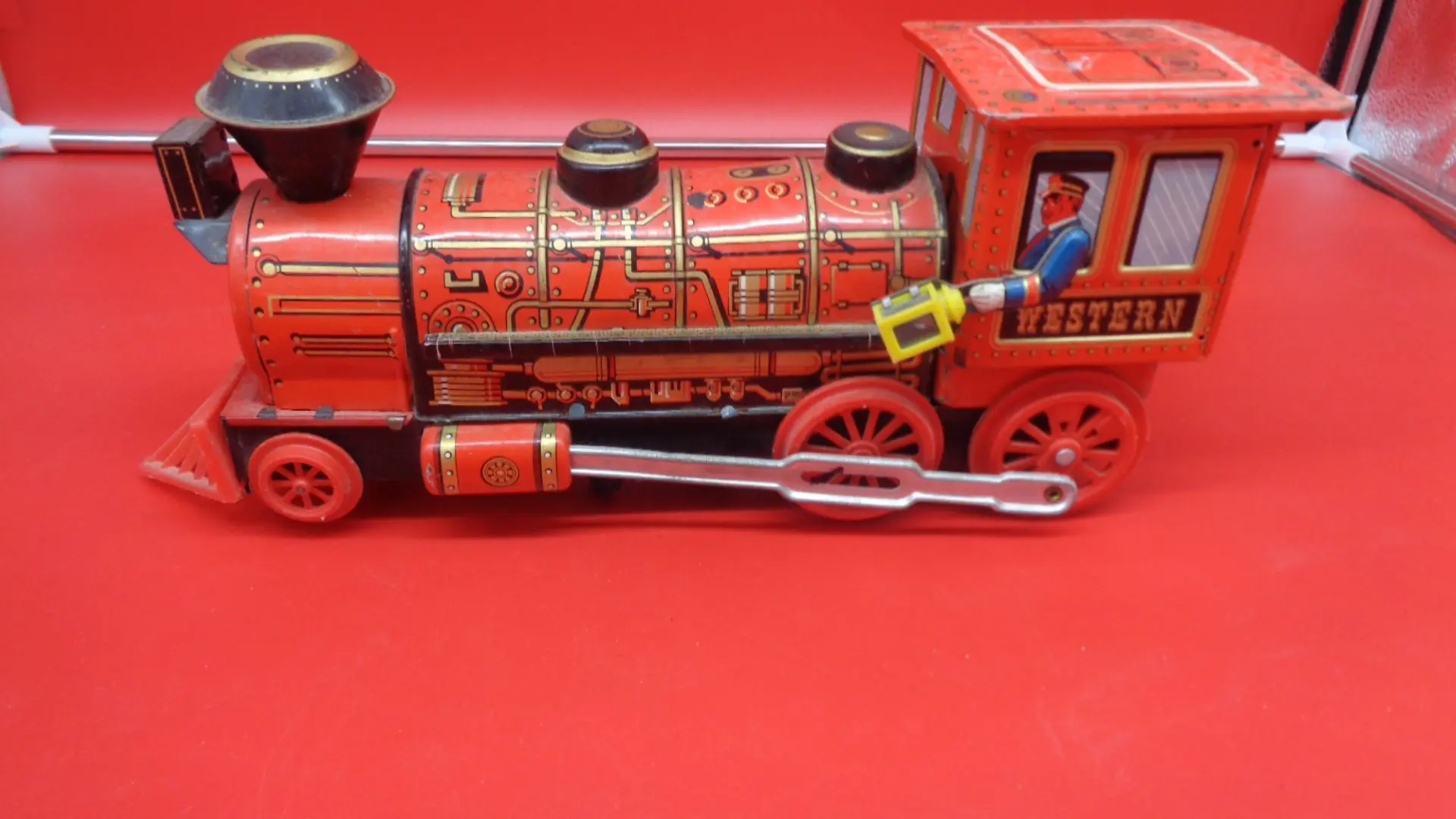 Red vintage toy steam train with the driver’s arm out