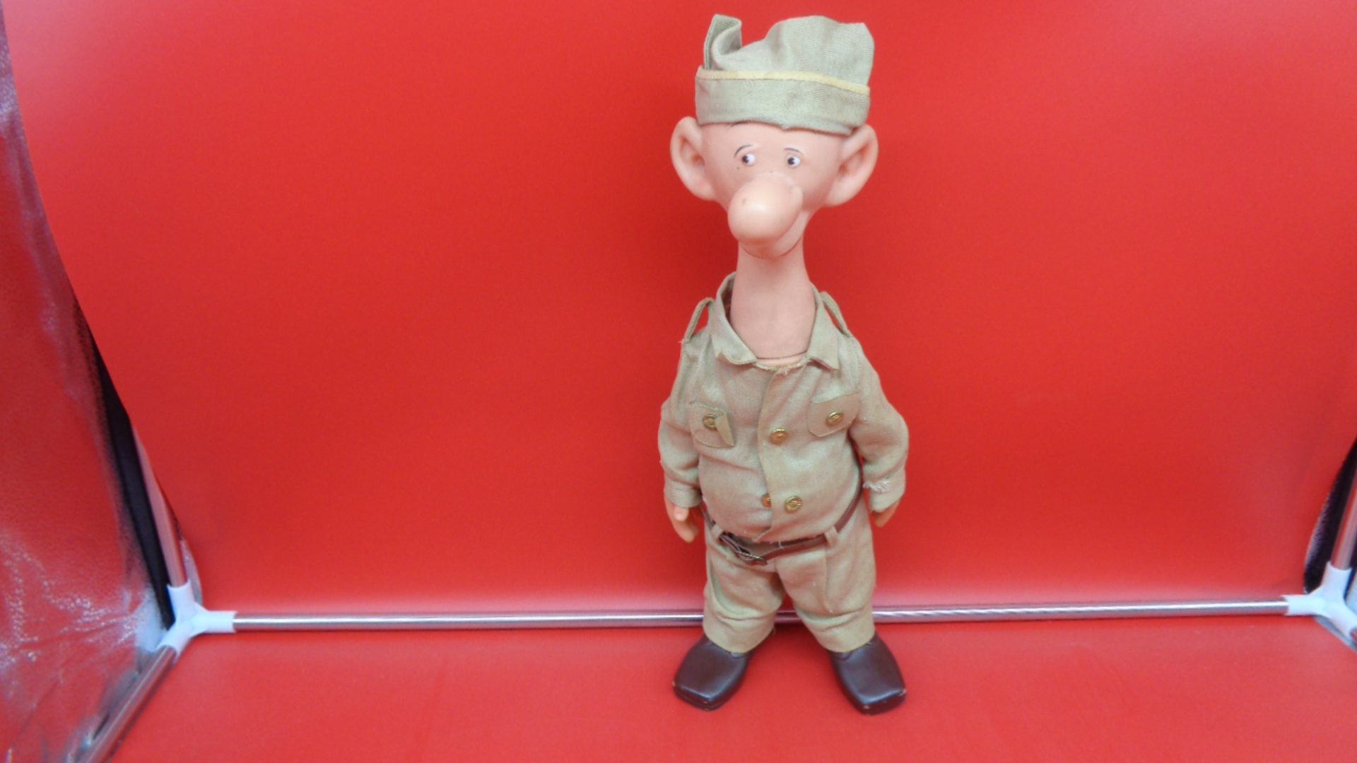 Display of front view of US Military US Army Sad Sack Doll